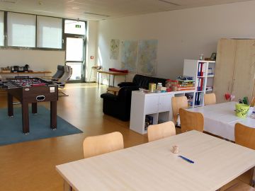 Betreuungsraum der BEB in Norderstedt mit Tischkicker, Sofaecke und Tischen und Stühlen in der offenen Ganztagsschule Schulzentrum Süd in Norderstedt