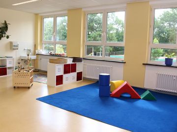 Kreativraum mit Spieleteppich und Regalen in der BEB an der OGGS Friedrichsgabe