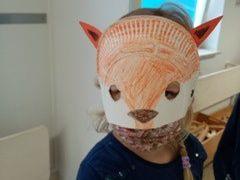 Kind mit selbstgebastelter Fuchsmaske, die das ganze Gesicht verdeckt