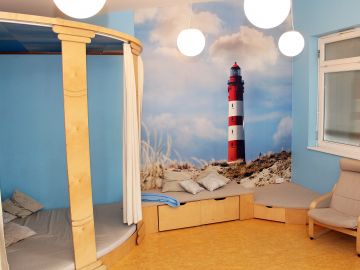 Blau gestrichener Relaxraum der BEB mit Kuschel- und Versteckecke sowie Sessel an der offenen Ganztagsgrundschule Heidberg in Norderstedt