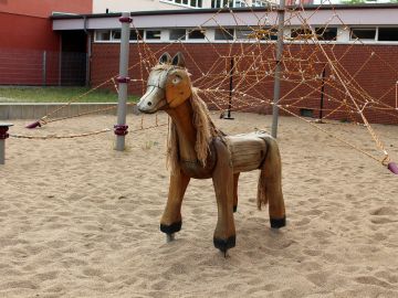Holzspielpferd und Spielplatz der OGGS Gottfried-Keller in Norderstedt