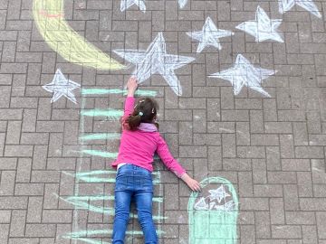 Kreidebild auf dem Schulhof der OGGS Falkenberg mit einem Kind