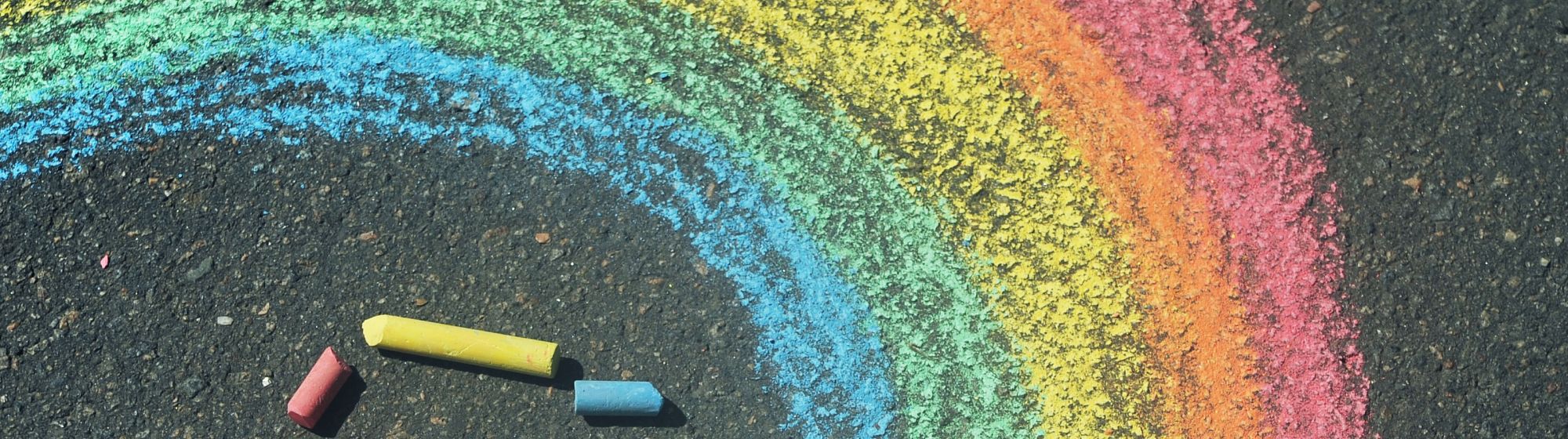 Kreideregenbogen mit Kreidestiften auf einem Außenboden