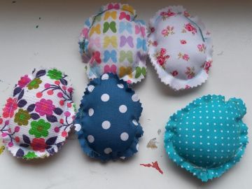 Fünf bunte, genähte Stoffostereier auf einem Tisch