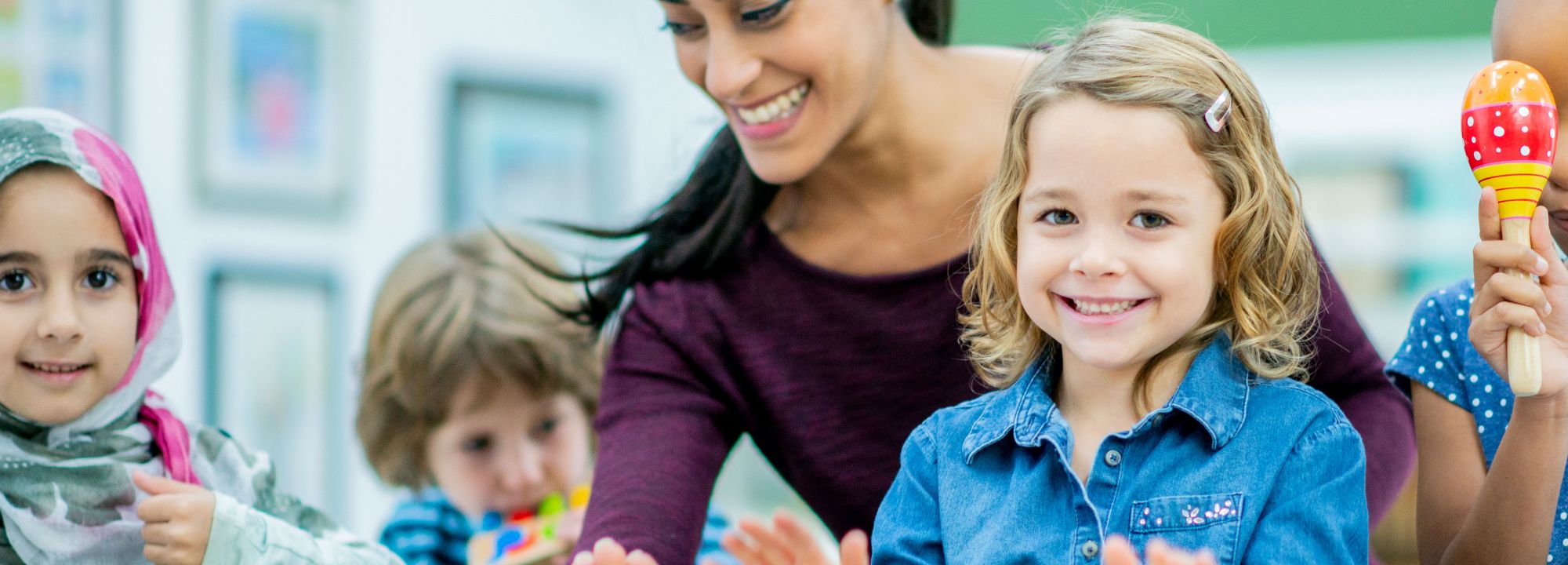 Schulkinder spielen verschiedene Musikinstrumente mit einer Betreuerin