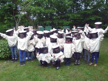 Bienenkinder der OGGS Immenhorst kümmern sich mit Imker um den Bienenstock